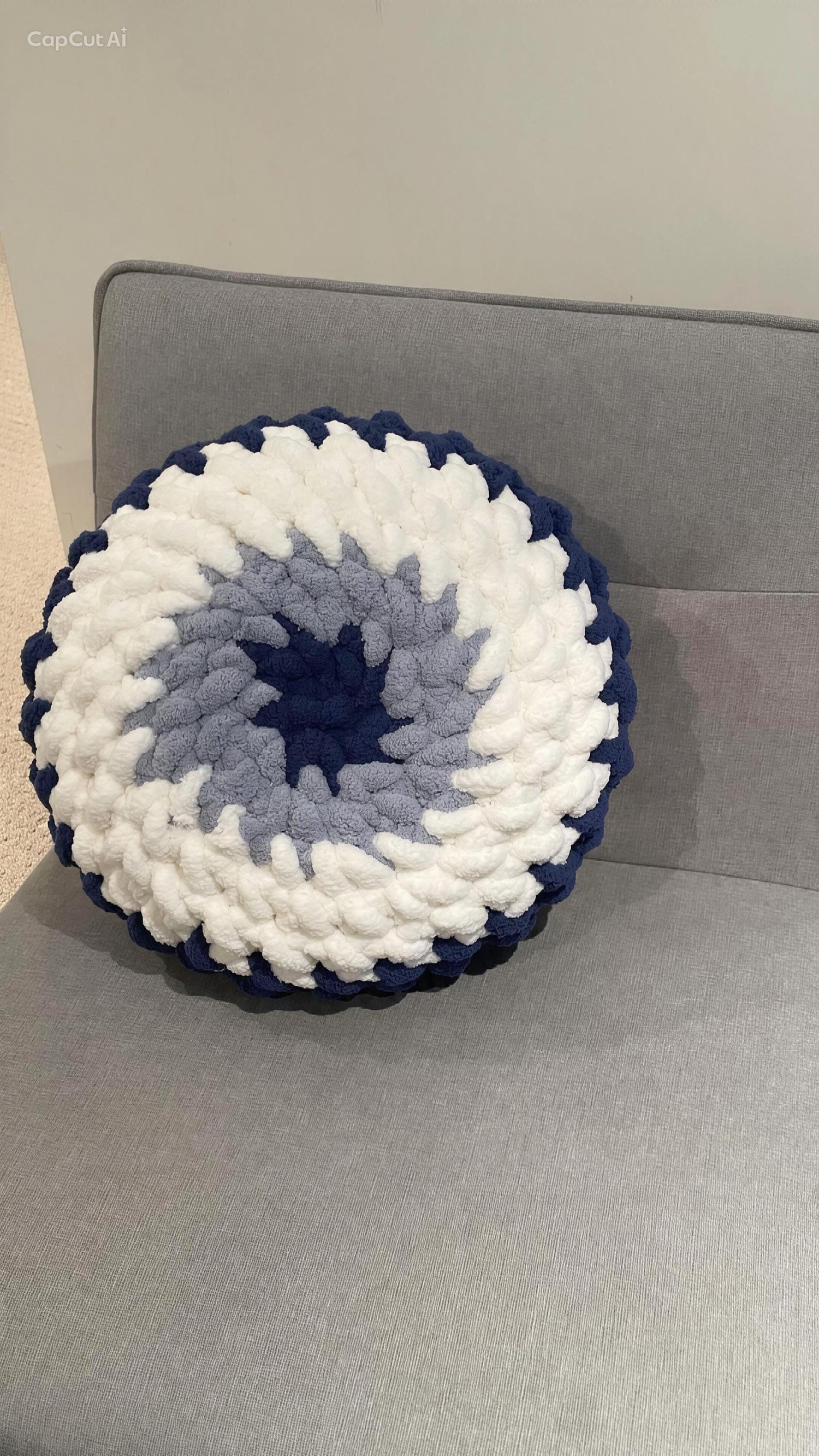 Finger crochet evil eye pillow in navy, sky blue and vintage white chunky yarn - finished pillow from the pattern